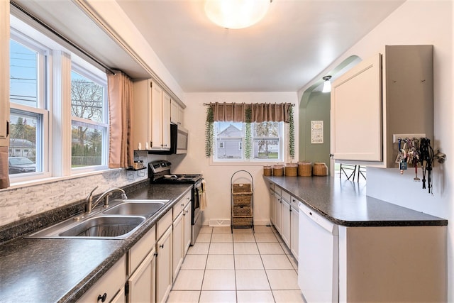 kitchen with sink, light tile patterned floors, stainless steel appliances, and plenty of natural light