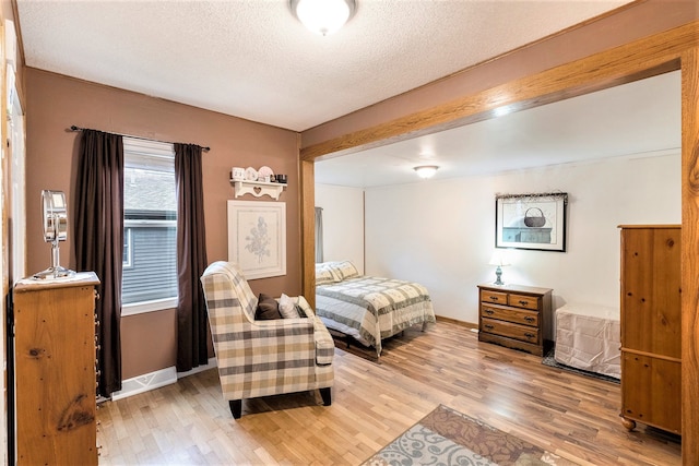 bedroom with a textured ceiling and hardwood / wood-style flooring