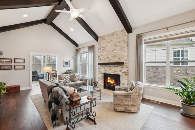 living room with hardwood / wood-style floors, high vaulted ceiling, ceiling fan, a fireplace, and beam ceiling