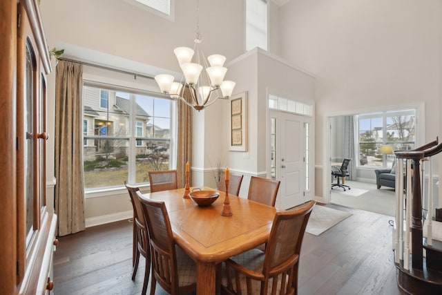 dining room featuring a high ceiling, dark hardwood / wood-style floors, and an inviting chandelier