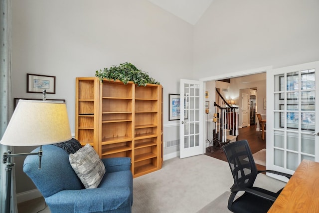 carpeted office space featuring high vaulted ceiling and french doors