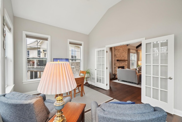 living area featuring a wealth of natural light, french doors, and dark hardwood / wood-style floors