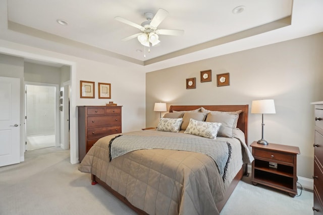 bedroom featuring a raised ceiling, ceiling fan, and light colored carpet