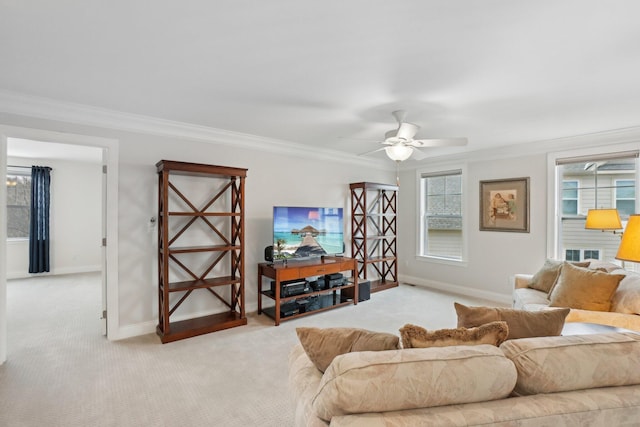 carpeted living room with ceiling fan and ornamental molding