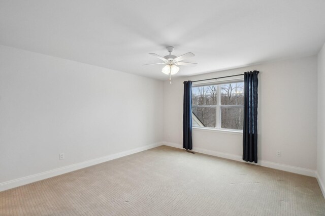 empty room with light colored carpet and ceiling fan