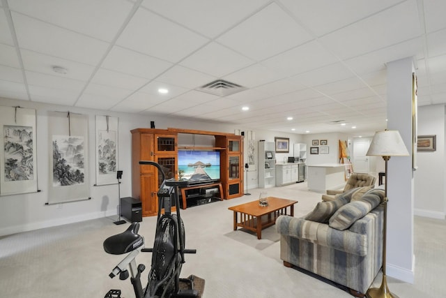 carpeted living room featuring a drop ceiling