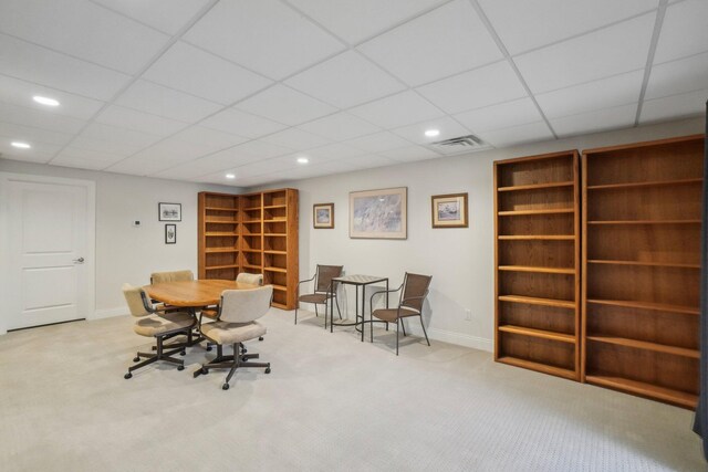 office featuring a paneled ceiling and light carpet