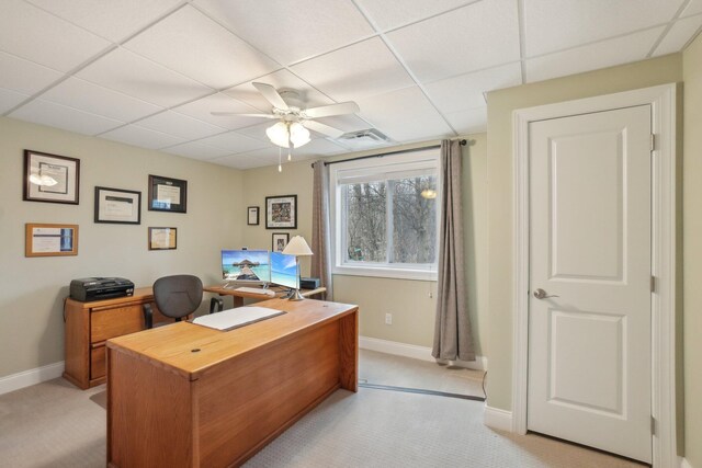 office area featuring a paneled ceiling, light colored carpet, and ceiling fan