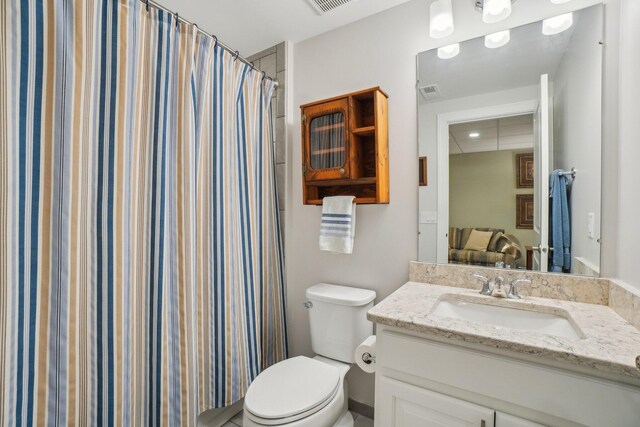 bathroom with a shower with curtain, vanity, and toilet