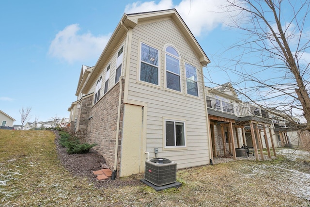 back of house with central AC unit and a deck