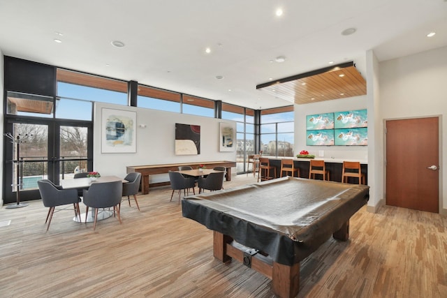 playroom featuring light hardwood / wood-style flooring, floor to ceiling windows, a healthy amount of sunlight, and pool table