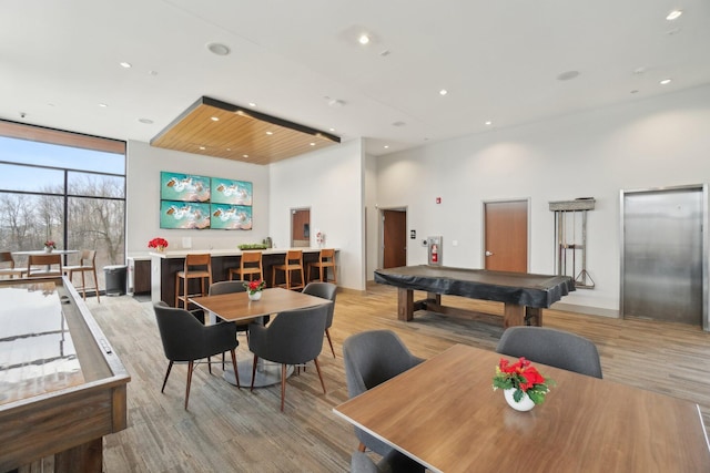 recreation room with elevator, billiards, floor to ceiling windows, and light wood-type flooring