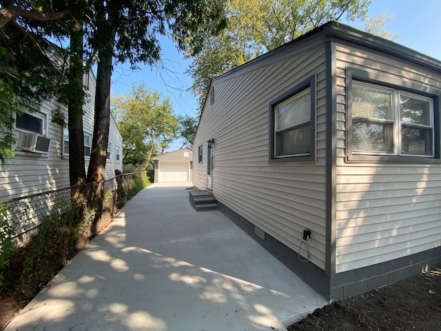 view of side of property featuring an outbuilding, a garage, and cooling unit