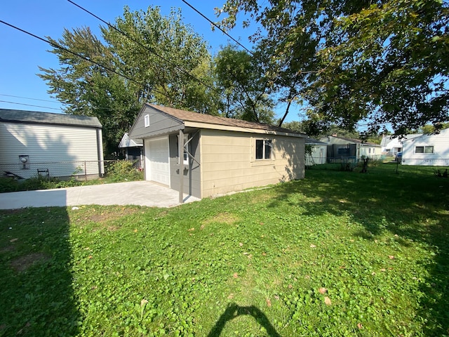 exterior space featuring a garage, a yard, and an outbuilding