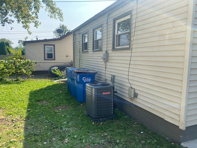 view of property exterior featuring a lawn and cooling unit