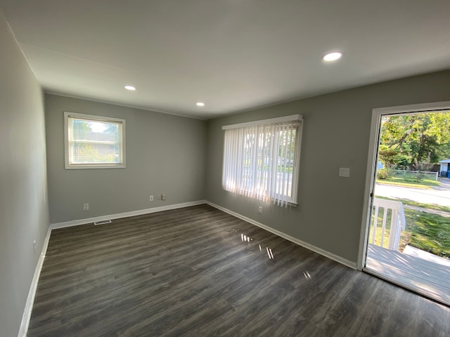 unfurnished room with a healthy amount of sunlight and dark wood-type flooring