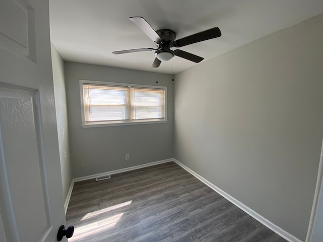 spare room featuring ceiling fan and dark wood-type flooring