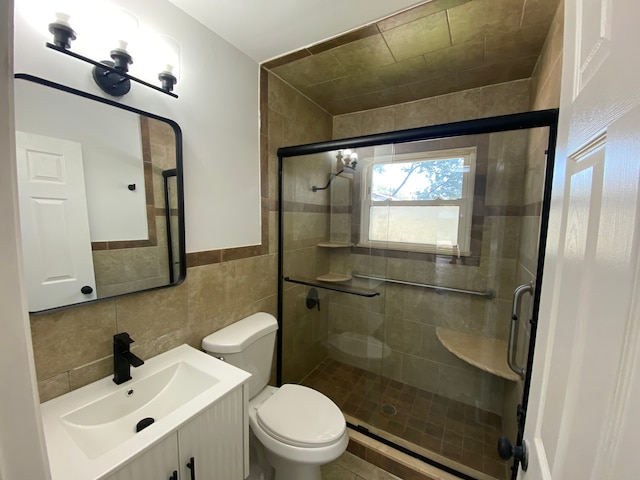 bathroom with vanity, toilet, tile walls, and walk in shower