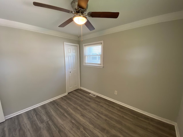 spare room with dark hardwood / wood-style floors, ceiling fan, and ornamental molding