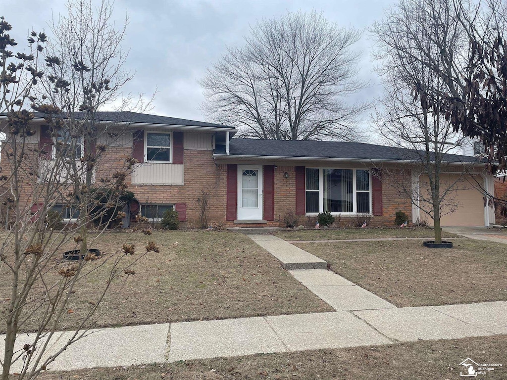 split level home with a garage and a front yard