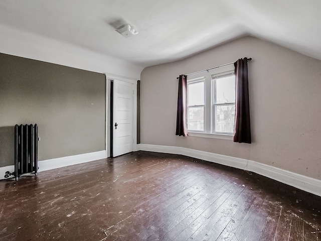 additional living space featuring dark wood-type flooring, radiator, and lofted ceiling