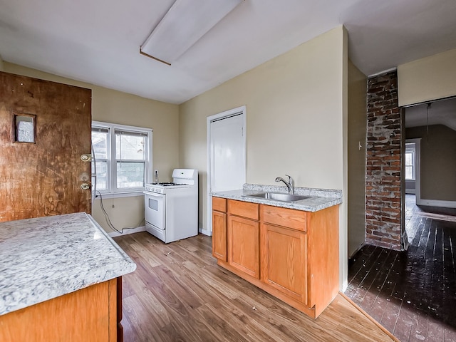 kitchen with white range with gas cooktop, sink, and wood-type flooring