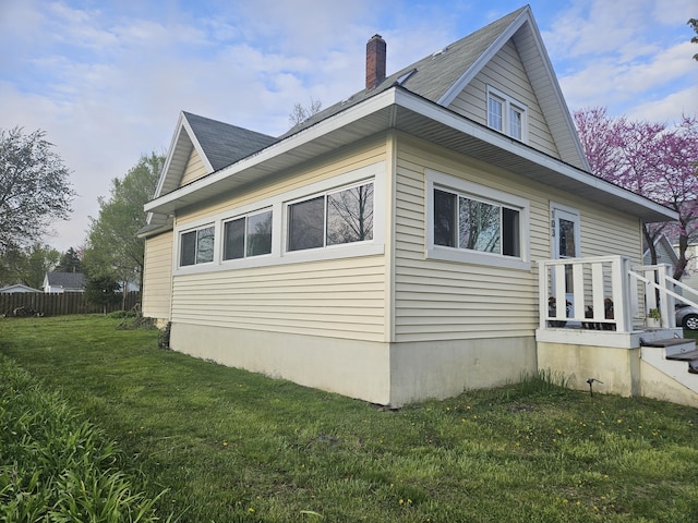 103 E Maple St, Three Oaks, MI 49128 - view of property exterior with a lawn, fence, and a chimney