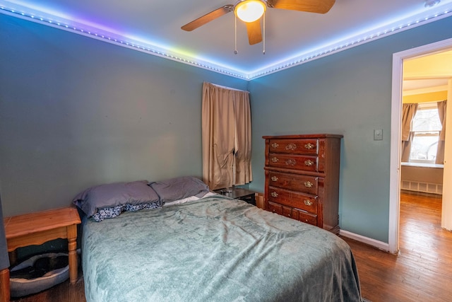 bedroom featuring ceiling fan, wood-type flooring, and radiator heating unit