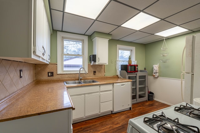 kitchen with a paneled ceiling, sink, white appliances, and white cabinetry