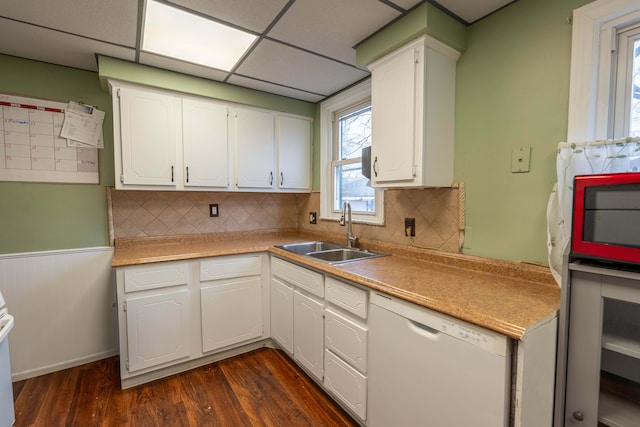 kitchen featuring white cabinets, a drop ceiling, dishwasher, and sink