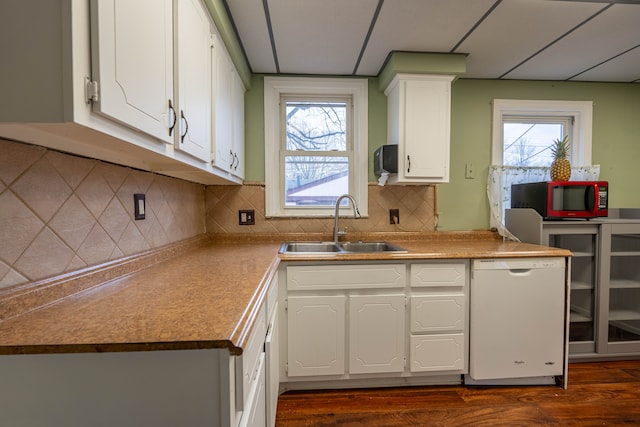 kitchen with a drop ceiling, sink, white dishwasher, and white cabinetry