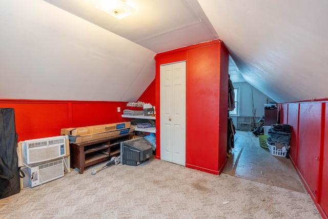 additional living space featuring light carpet, vaulted ceiling, and a wall mounted air conditioner