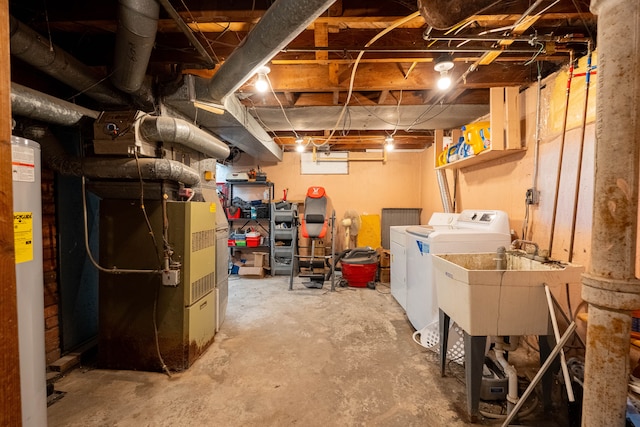 basement with heating unit, water heater, sink, and washing machine and clothes dryer