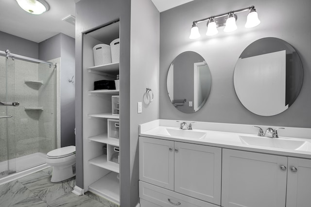 bathroom featuring vanity, toilet, and a shower with shower door