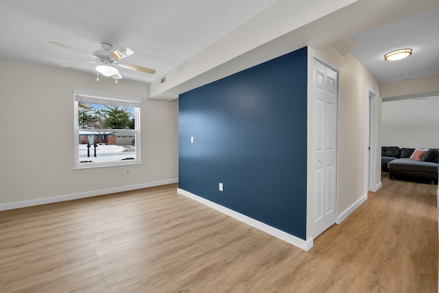 empty room with ceiling fan and light hardwood / wood-style flooring