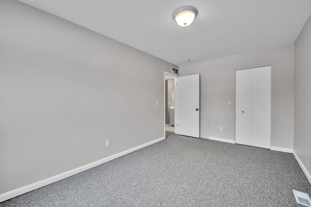 unfurnished bedroom featuring carpet flooring and a closet