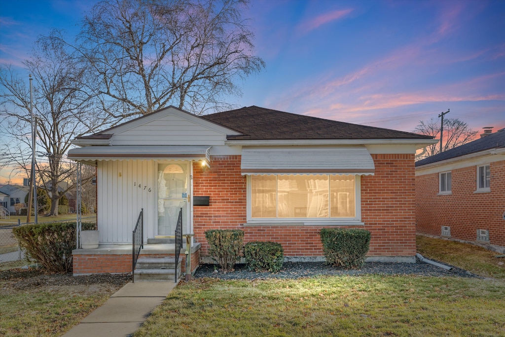 bungalow-style home with a lawn