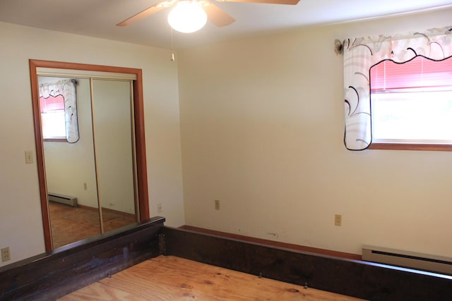 empty room featuring a baseboard radiator and ceiling fan