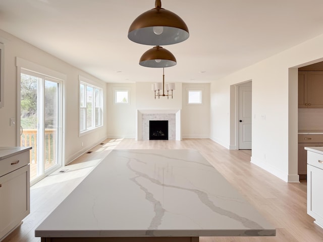 unfurnished living room featuring light wood-style floors, baseboards, and a fireplace