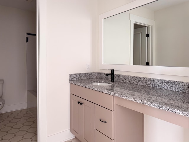 full bathroom featuring toilet, tile patterned floors, baseboards, and vanity