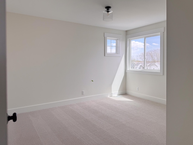 carpeted spare room featuring baseboards