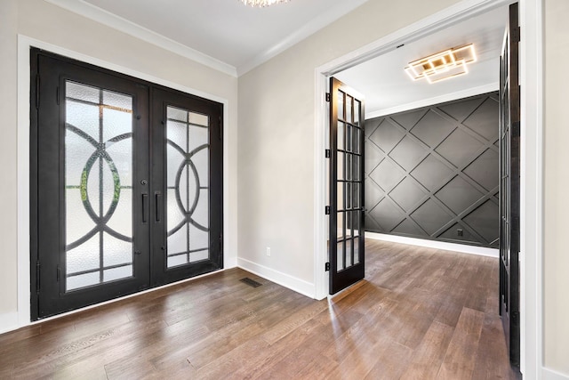 entrance foyer featuring french doors, hardwood / wood-style flooring, and ornamental molding