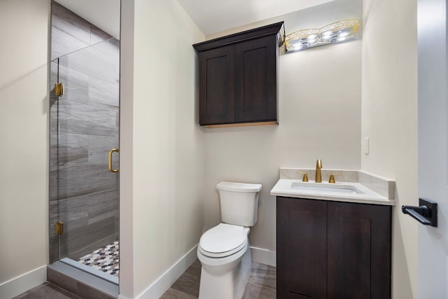 bathroom featuring vanity, toilet, and a shower with shower door