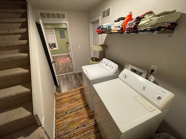 laundry room with separate washer and dryer and dark wood-type flooring