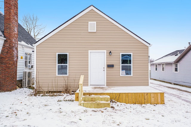 snow covered house with ac unit