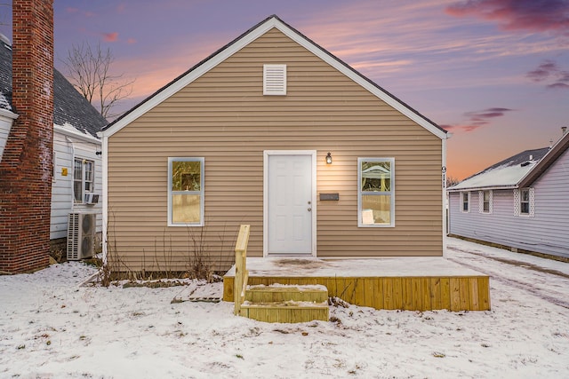 snow covered property with ac unit and central AC