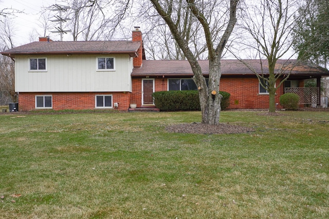 split level home with cooling unit and a front yard