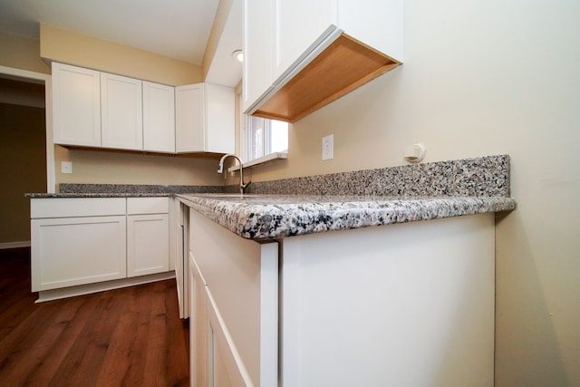 kitchen featuring dark hardwood / wood-style flooring, sink, white cabinets, and stone countertops