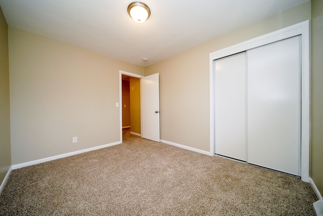 unfurnished bedroom featuring carpet flooring and a closet