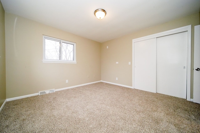 unfurnished bedroom featuring carpet flooring and a closet